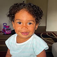 Jalin joined the competition — help win amazing prizes! toddler, child, curly_hair, smiling, indoor, toy_car, light_blue_clothing, bright_eyes, happy, portrait, person, cute, baby, young_child, sitting, home, carpet, furniture, playtime, close_up
