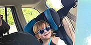 Esteban participe au concours pour gagner de l'argent avec cette photo : child, toddler, car_seat, sunglasses, blue, bottle, car_interior, seatbelt, window, sunlight, happy, smiling, hair, clothing, seat, person, travel, road_trip, summer, casual
