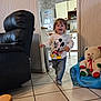 Esteban participe au concours pour gagner de l'argent avec cette photo : toddler, child, running, mickey_mouse, shirt, jeans, indoor, living_room, chair, black_leather_chair, teddy_bear, child_chair, tile_floor, kitchen, cabinet, refrigerator, happy, smiling, toy, casual_clothing