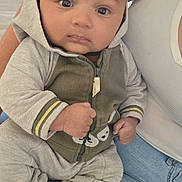 Kiéran a rejoint le concours — aidez-le/la à gagner de superbes lots ! baby, casual, child, closeup, clothing, cozy, cute, expression, face, fist, hoodie, human, indoor, infant, jeans, looking, person, seated, socks, tank_top