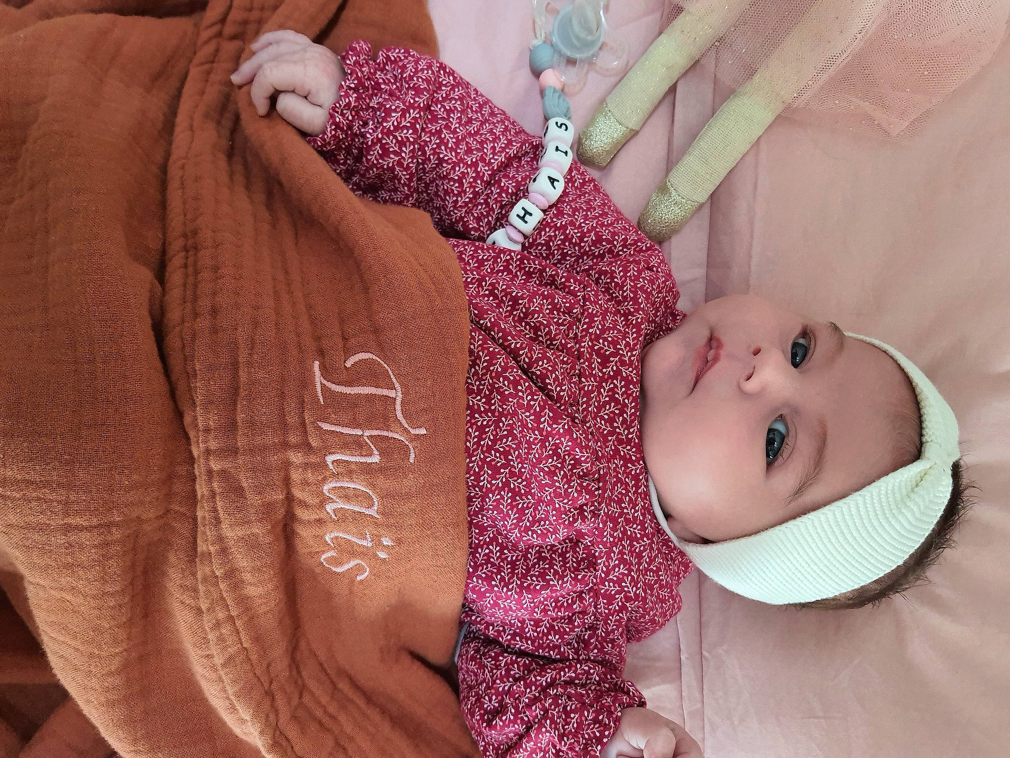 Thaïs participe au concours pour gagner de l'argent avec cette photo : arm, baby, baby_toddler_clothing, eyelash, finger, gesture, hand, headwear, human_body, joint, lip, nail, neck, person, pink, purple, skin, sleeve, smile, textile