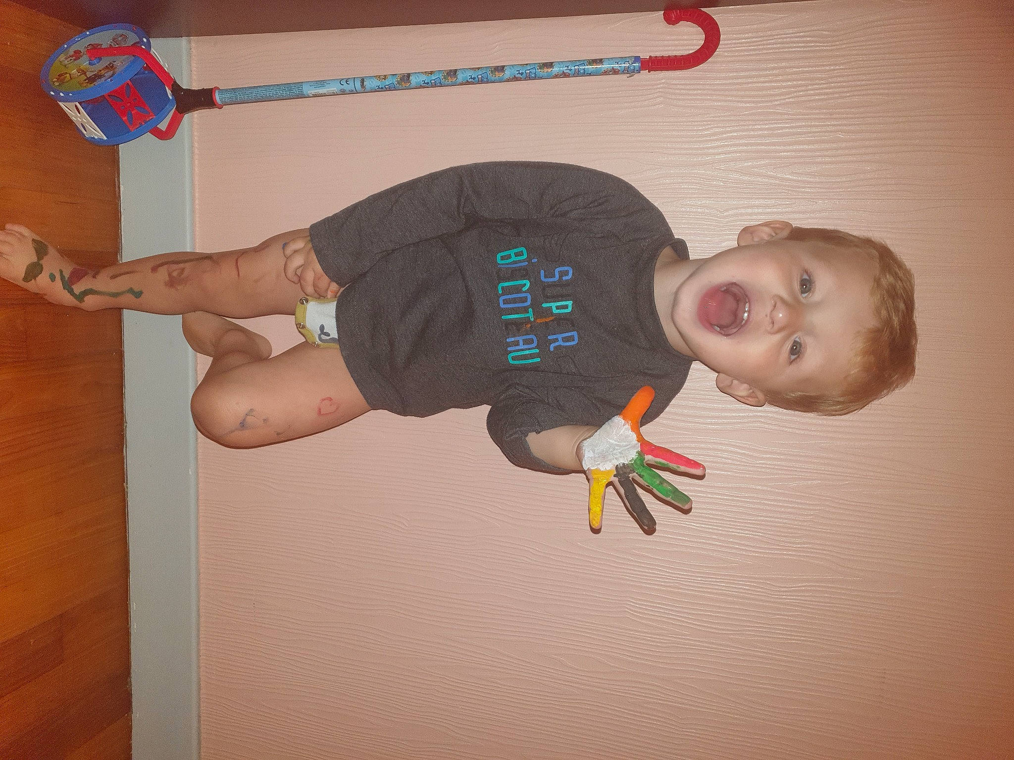 Ilann participe au concours pour gagner de l'argent avec cette photo : baby_toddler_clothing, balance, elbow, finger, flooring, fun, gesture, human_leg, joint, knee, leg, person, room, sleeve, sportswear, surprise, t_shirt, thigh, thumb, toddler