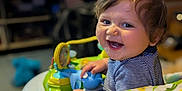 Elrey joined the competition — help win amazing prizes! baby, smiling, walker, toy, indoor, child, dinosaur_pattern, happy, blue_eyes, striped_shirt, curly_hair, face, seat, playtime, infant, cheerful, colorful, furniture, home, closeup