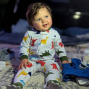 Elrey joined the competition — help win amazing prizes! toddler, child, baby, pajamas, dinosaur_pattern, sitting, blanket, blue_eyes, indoor, soft_lighting, baby_bottle, pacifier, clothing, footwear, curly_hair, cozy, bedtime, cute, expression, portrait