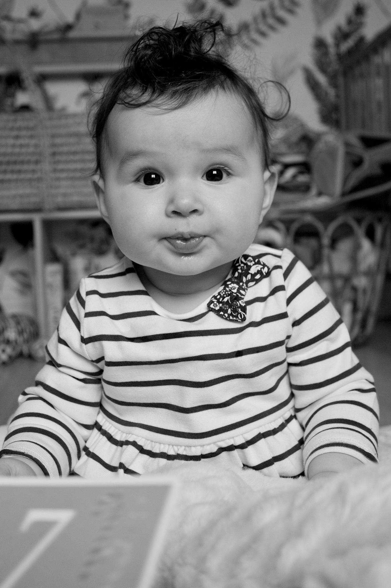 Capucine a rejoint le concours — aidez-le/la à gagner de superbes lots ! black, black_and_white, cheek, eye, face, facial_expression, flash_photography, forehead, hairstyle, happy, head, iris, monochrome, person, smile, standing, style, tire, toddler, wheel