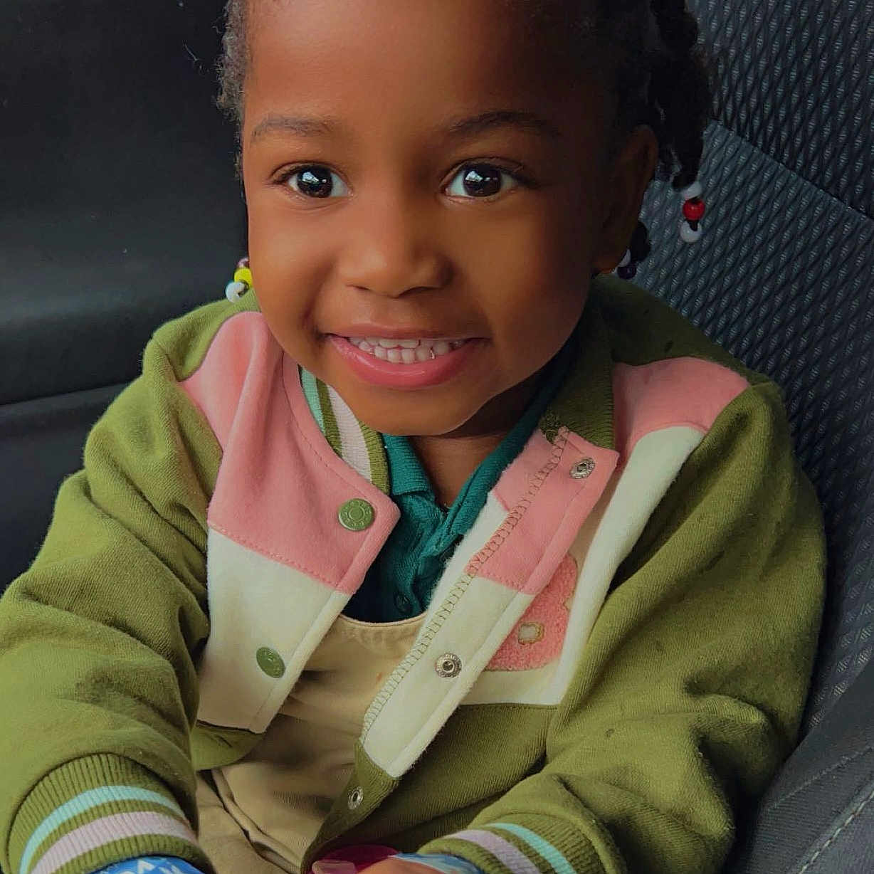 Blake is registered to the contest to win money with this photo: accessories, baby, babylaughing, blazer, child, clothing, coat, face, female, girl, hair, happy, head, jacket, jewelry, person, photography, portrait, sitting, smile