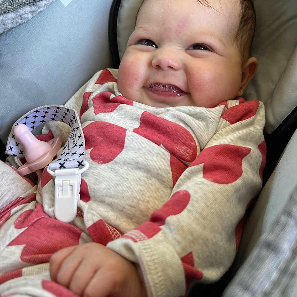 Merrilynn joined the competition — help win amazing prizes! baby, car_seat, cheeks, child, clip, closeup, clothing, cute, fabric, face, hand, happy, heart_pattern, indoor, infant, onesie, pacifier, portrait, seat, smiling
