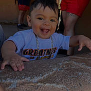 Axel joined the competition — help win amazing prizes! toddler, child, smiling, happy, face, person, necklace, clothing, tshirt, hand, stone_surface, outdoor, people, legs, shorts, tattoo, casual, background, portrait, daylight