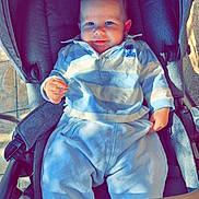 Alessio participe au concours pour gagner de l'argent avec cette photo : baby, child, stroller, blue_clothing, socks, smiling, face, infant, casual, outdoor, sunlight, shadow, floor, tile, hands, cute, seated, person, happy, cozy