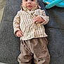 Alessio a rejoint le concours — aidez-le/la à gagner de superbes lots ! baby, infant, child, couch, clothing, striped_shirt, brown_pants, black_sneakers, nike, footwear, blanket, floor, tile_floor, indoor, person, portrait, casual, relaxed, looking_at_camera, seated