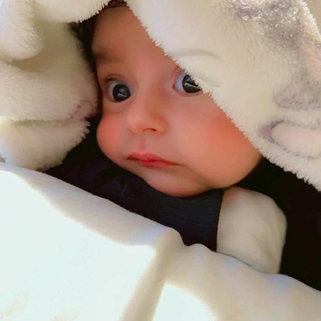 Muhammad Balaaj is registered to the contest to win money with this photo: baby, blanket, child, closeup, comfort, cozy, curious, cute, expression, face, indoors, infant, portrait, sleepwear, snug, soft, warm, wide_eyes, wrapped, young_child