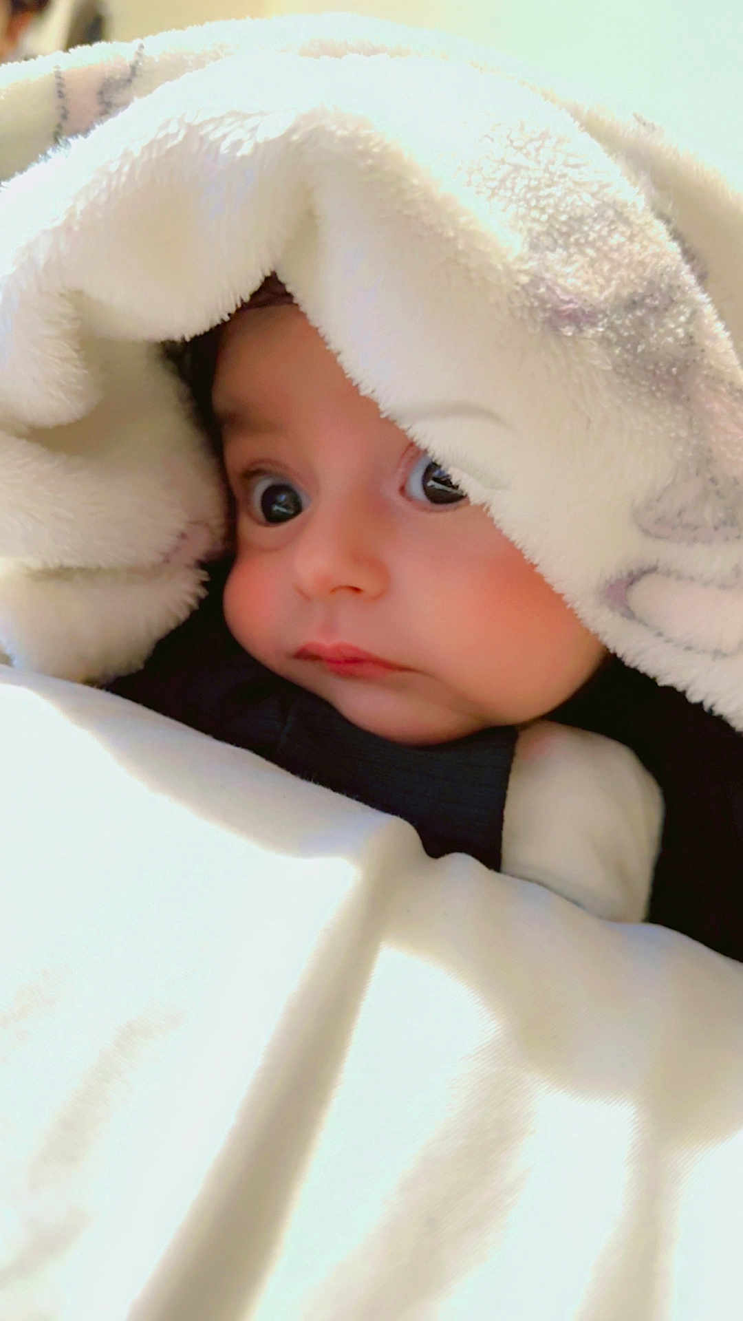 Muhammad Balaaj is registered to the contest to win money with this photo: baby, blanket, face, child, curious, cozy, soft, indoors, portrait, cute, wide_eyes, warm, snug, infant, young_child, wrapped, sleepwear, closeup, expression, comfort
