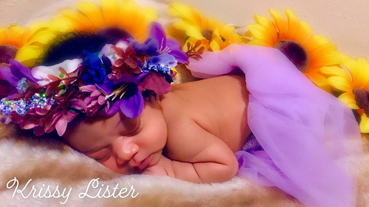 Krissy is registered to the contest to win money with this photo: baby, child, fashion_accessory, flower, hair_accessory, hand, headband, headgear, headpiece, headwear, lavender, person, petal, plant, purple, sleep, violet, yellow