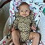 baby, infant, child, spotted_clothing, blanket, footprint_pattern, baby_seat, toy, plush_toy, face, legs, hands, indoor, comfort, cute, smile, person, young_child, portrait, cozy