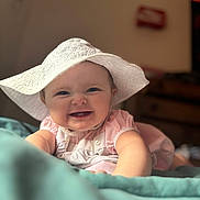 Esmaee is registered to the contest to win money with this photo: baby, child, smiling, hat, pink_clothing, blanket, indoor, portrait, cute, happy, face, infant, young_child, soft_lighting, closeup, baby_girl, skin, person, apparel, headwear