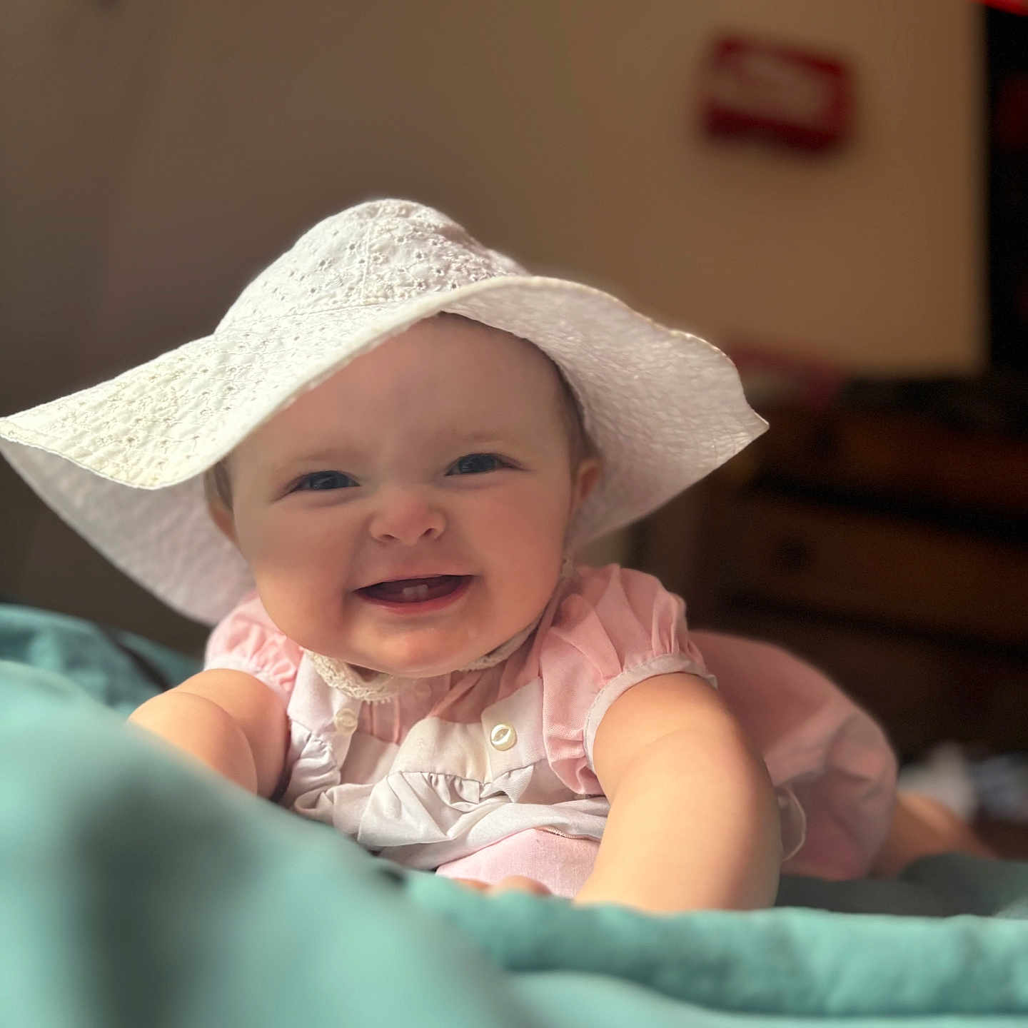 Esmaee is registered to the contest to win money with this photo: apparel, baby, baby_girl, blanket, child, closeup, cute, face, happy, hat, headwear, indoor, infant, person, pink_clothing, portrait, skin, smiling, soft_lighting, young_child