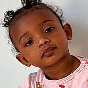 Ayanna a rejoint le concours — aidez-le/la à gagner de superbes lots ! child, toddler, portrait, face, eyes, curly_hair, pigtails, expression, pink_pajamas, animal_print, skin_tone, ear, nose, close_up, indoor, neutral_background, soft_lighting, eyelashes, baby, sitting