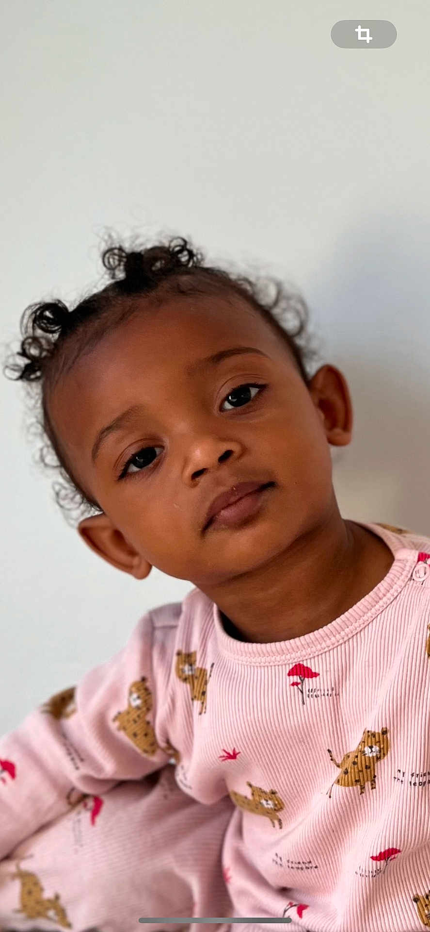 Ayanna a rejoint le concours — aidez-le/la à gagner de superbes lots ! child, toddler, portrait, face, eyes, curly_hair, pigtails, expression, pink_pajamas, animal_print, skin_tone, ear, nose, close_up, indoor, neutral_background, soft_lighting, eyelashes, baby, sitting