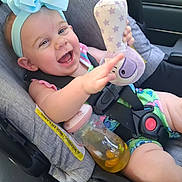 Nevah joined the competition — help win amazing prizes! baby, car_seat, child, smiling, toy, bottle, blue_bow, happy, infant, seatbelt, clothing, indoor, person, cute, playful, cheerful, small_child, car, seat, accessory