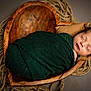 newborn, baby, sleeping, swaddled, blanket, wooden_bowl, ropes, cozy, portrait, infant, cute, peaceful, wrapped, head, face, indoors, warm, soft_light, resting, child