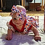 baby, infant, tummy_time, patriotic_clothing, headband, blanket, carpet, living_room, fireworks, stars, stripes, red, white, blue, indoor, person, smiling, cute, celebration, floor