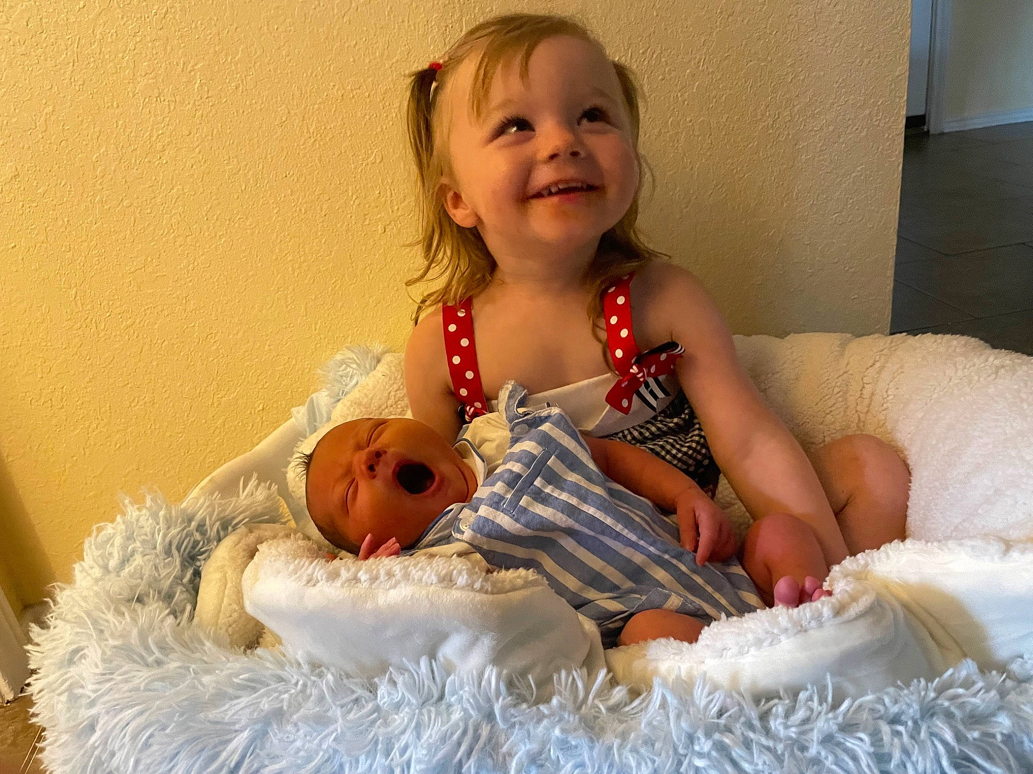 Brinley is registered to the contest to win money with this photo: abdomen, arm, baby, baby_toddler_clothing, comfort, event, facial_expression, finger, foot, fun, hand, happy, iris, joy, linens, person, room, sitting, skin, smile