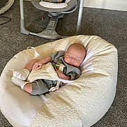 Rome is registered to the contest to win money with this photo: baby, sleeping, beanbag, blanket, carpet, indoor, baby_swing, plush_toy, child, resting, soft_furniture, cozy, infant, clothing, home, flooring, comfort, peaceful, person, toddler