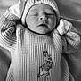 newborn, baby, knit_hat, knit_sweater, bunny_design, mittens, blanket, sleeping, infant, portrait, cozy, cute, soft_lighting, black_and_white, resting, child, indoors, peaceful, baby_clothing, close_up