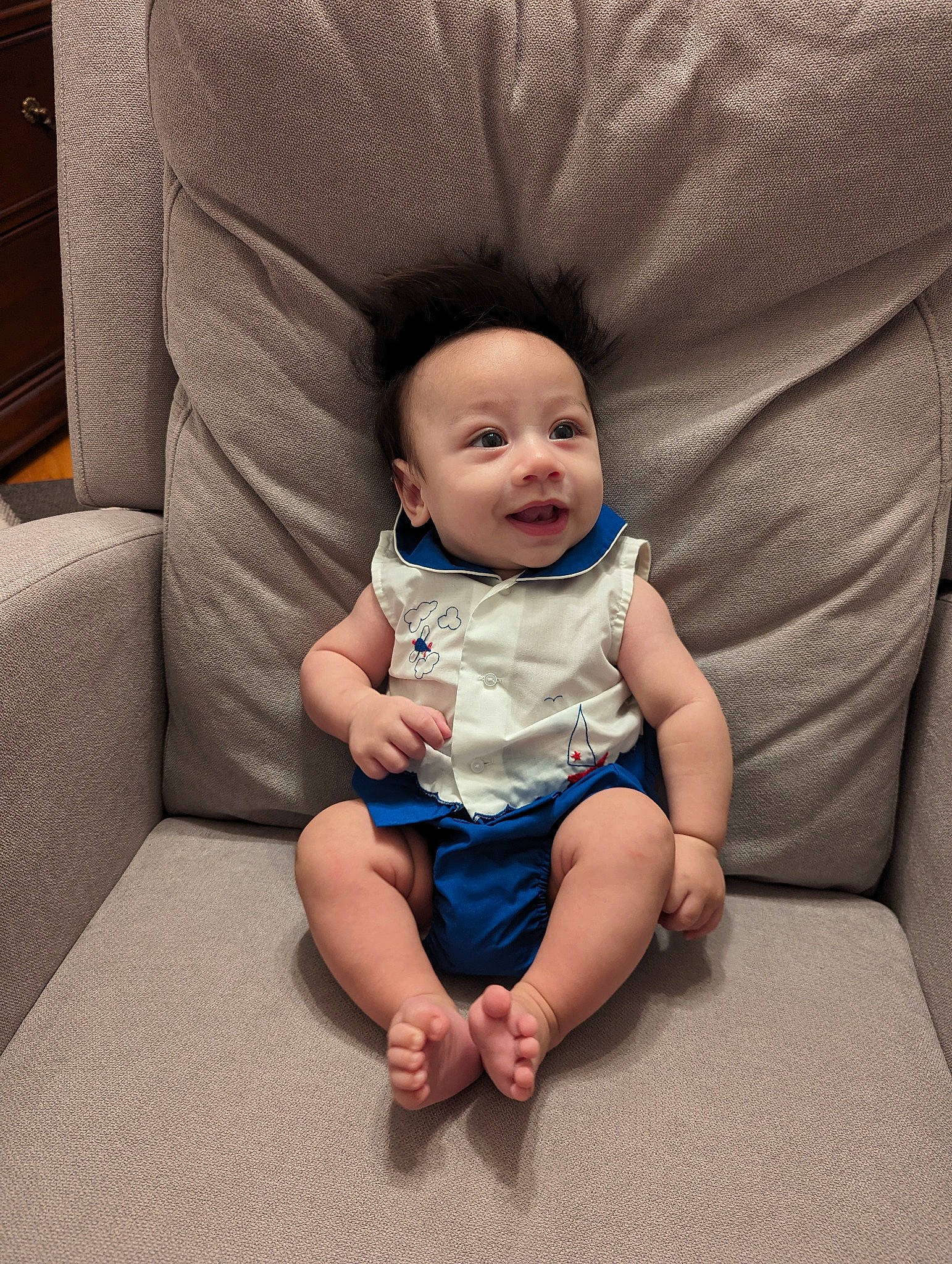Theo is registered to the contest to win money with this photo: baby, baby_toddler_clothing, barefoot, cheek, comfort, couch, electric_blue, flash_photography, flooring, foot, fun, hairstyle, happy, human_leg, lap, person, sitting, smile, textile, thigh