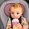 Echo is registered to the contest to win money with this photo: baby, blue_eyes, bottle, car_seat, child, clothing, cute, drink, expression, face, floral_pattern, flower, hand, infant, looking, milk, person, portrait, sitting, young_child