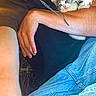 person, headphones, necklace, kitten, cat, jeans, arm, hand, black_shirt, blue_jeans, close_up, indoor, casual, pet, animal, cute, curious, comfort, holding, resting
