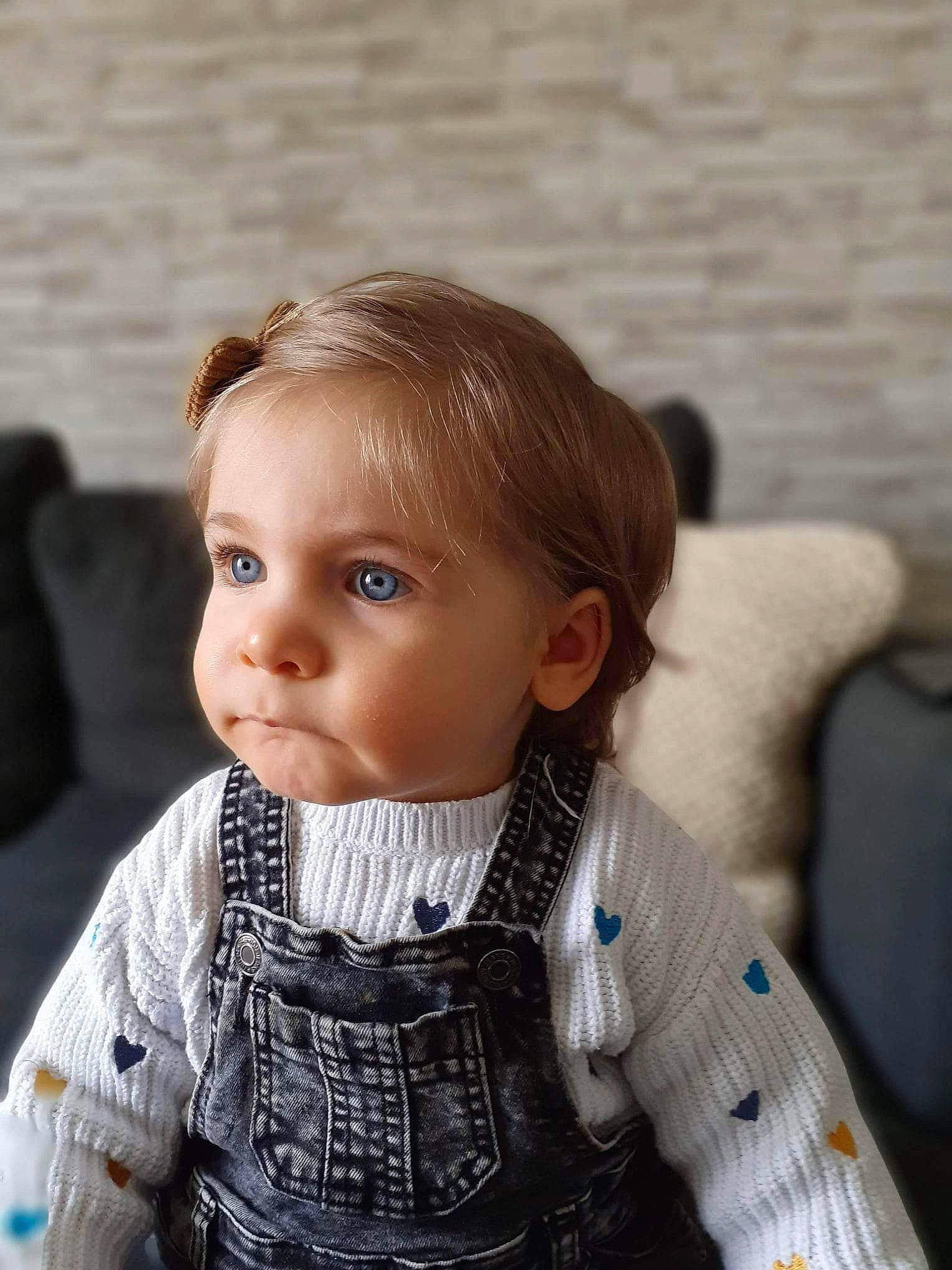 Lison a rejoint le concours — aidez-le/la à gagner de superbes lots ! baby_toddler_clothing, cheek, child, chin, eyelash, facial_expression, head, iris, lip, luggage_and_bags, neck, nose, pattern, person, sitting, skin, sleeve, toddler, wood, wool