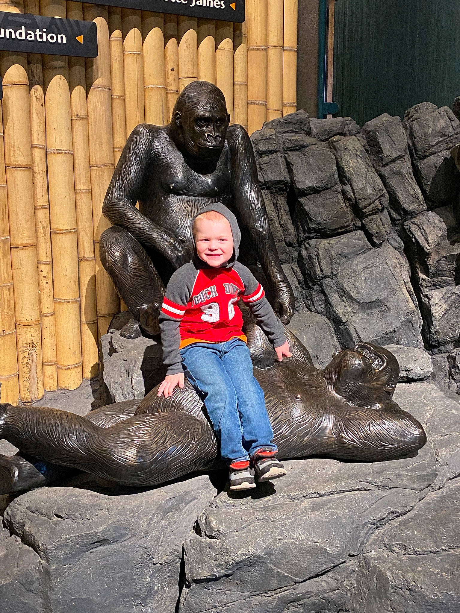 Klayton is registered to the contest to win money with this photo: art, child, fun, happy, headwear, interaction, joy, lawn_ornament, leisure, mammal, metal, monument, person, public_space, recreation, sculpture, sitting, smile, snout, standing