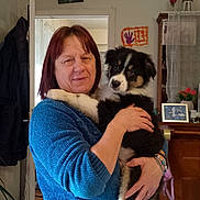 Aron participe au concours pour gagner de l'argent avec cette photo : woman, dog, puppy, indoor, holding, blue_sweater, smiling, furniture, painting, flowers, handmade_art, bracelet, door, coat, home, portrait, pet, cute, happy, cuddling