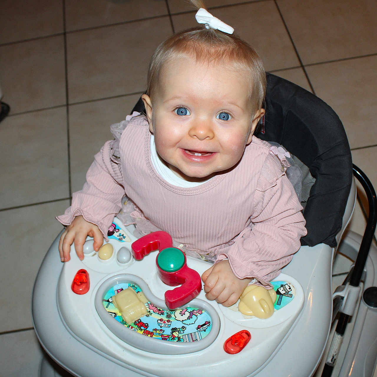 Steyla a rejoint le concours — aidez-le/la à gagner de superbes lots ! baby, blue_eyes, bow, candid, child, cute, family, floor_tiles, footwear, hands, happy, indoor, infant, person, pink_clothing, playing, smile, toy, walker, young_child