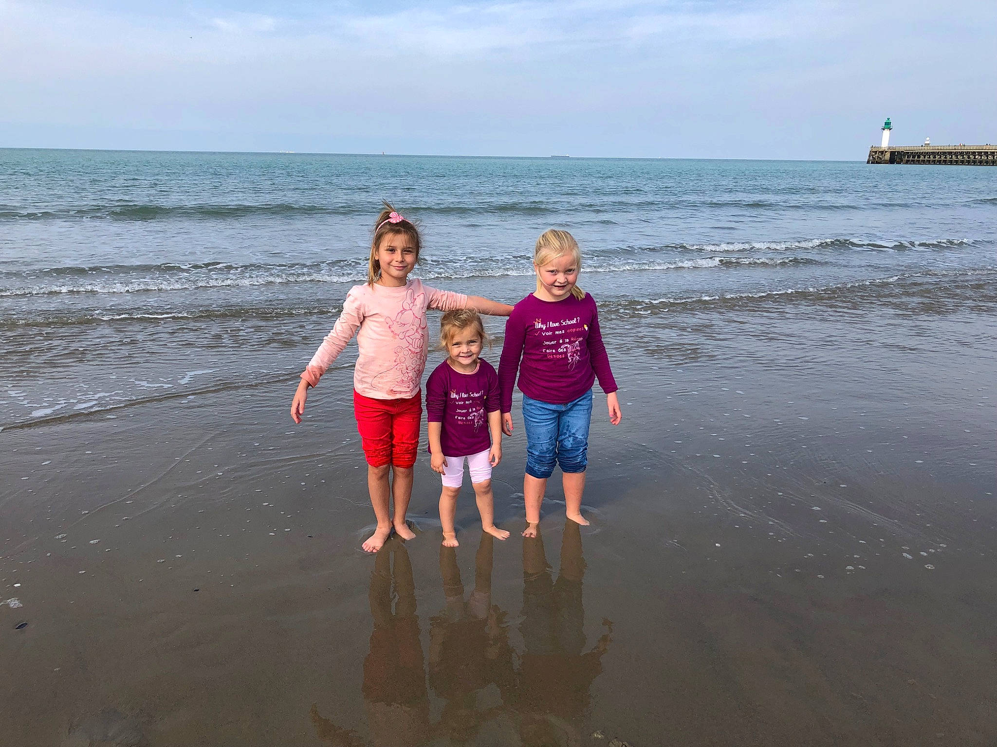 Laurena participe au concours pour gagner de l'argent avec cette photo : azure, beach, cloud, coastal_and_oceanic_landforms, fun, gesture, happy, horizon, joy, leisure, people_in_nature, people_on_beach, person, shorts, sky, smile, standing, summer, t_shirt, toddler