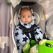 Isaiah joined the competition — help win amazing prizes! baby, infant, car_seat, harness, hooded_suit, star_pattern, plush_toy, green_toy, canopy, fabric, elephant_pattern, wide_eyes, surprised_expression, portrait, indoor, cozy, blanket, head_support, safety_label, gaze