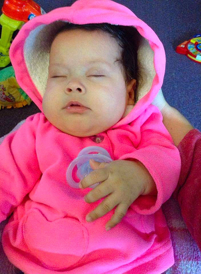 Yolanda is registered to the contest to win money with this photo: baby, baby_toddler_clothing, cheek, eye, eyebrow, gesture, grass, happy, headgear, lip, mouth, nose, outerwear, person, pink, purple, skin, sleeve, smile, textile