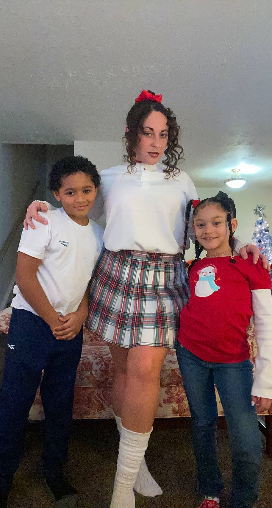 Mckenna is registered to the contest to win money with this photo: belt, event, face, fashion_design, fun, hairstyle, human_leg, joy, knee, leg, person, plaid, red, school_uniform, smile, sock, tartan, thigh, trunk, uniform