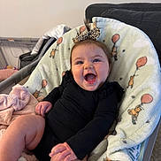 Sarah joined the competition — help win amazing prizes! baby, infant, smiling, happy, black_clothing, bow, hair_accessory, blanket, teddy_bear_pattern, balloon_pattern, indoors, couch, soft_texture, cute, child, person, infant_clothing, seated, cheerful, home