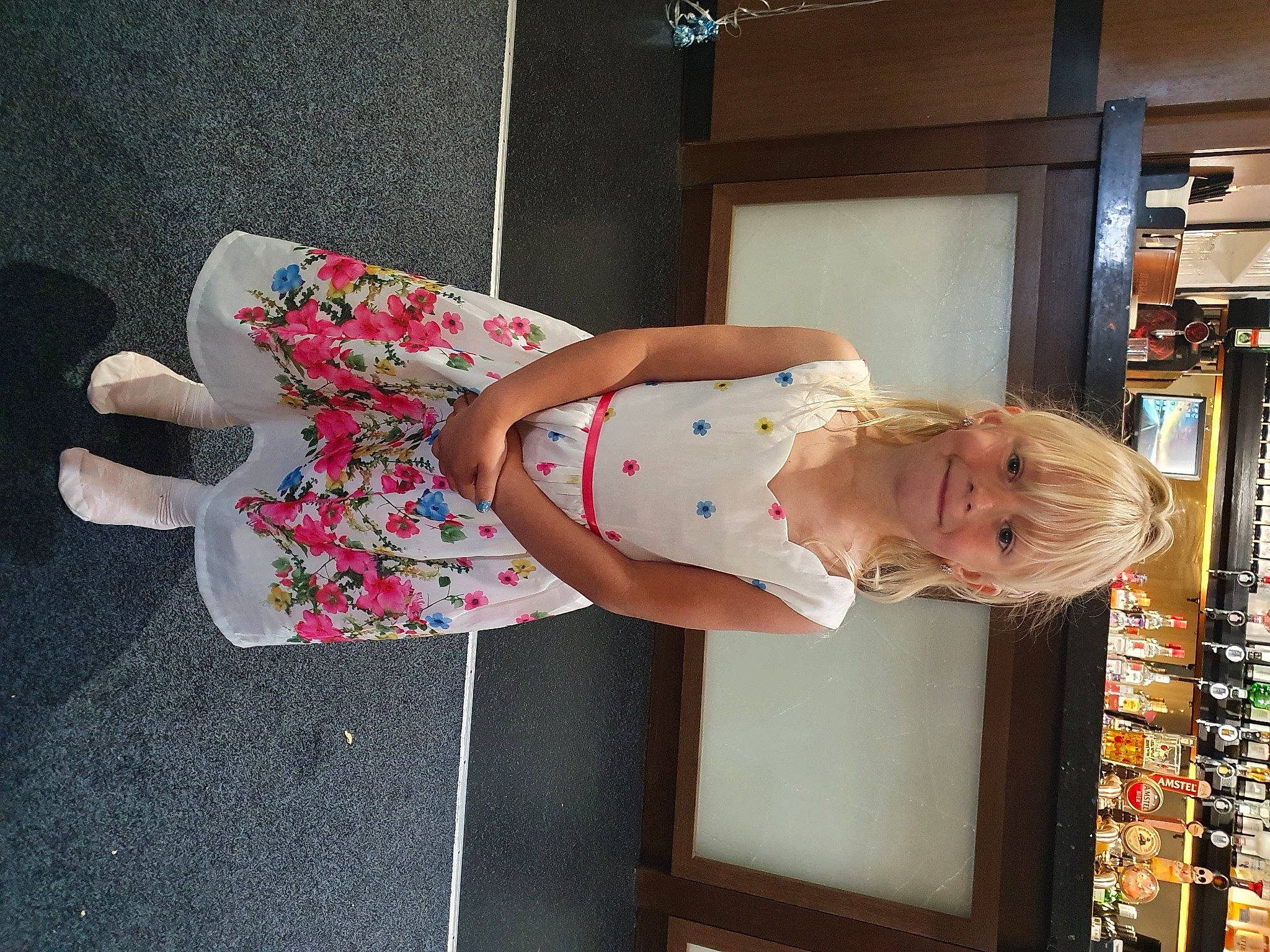 Crystal is registered to the contest to win money with this photo: baby_products, baby_toddler_clothing, child, comfort, dress, flooring, fun, human_leg, joy, knee, pattern, person, product, room, shelf, shelving, sock, standing, thigh, toddler