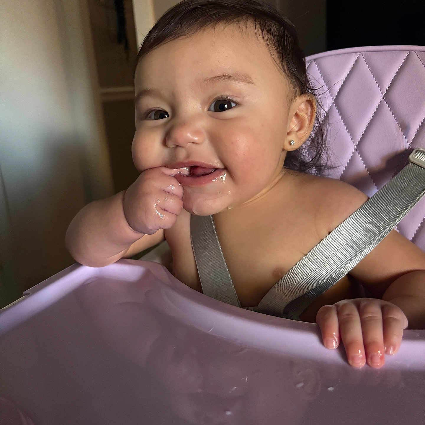 Jasliani is registered to the contest to win money with this photo: baby, child, cute, domestic, earring, face, finger_in_mouth, hair, happy, harness, high_chair, indoor, infant, person, reflection, seat, skin, smiling, table, toddler