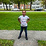 birthday, black_shoes, cars, celebration, child, daytime, girl, grass, happy, houses, jeans, outdoor, person, posing, sidewalk, smiling, suburban, trees, tshirt, young