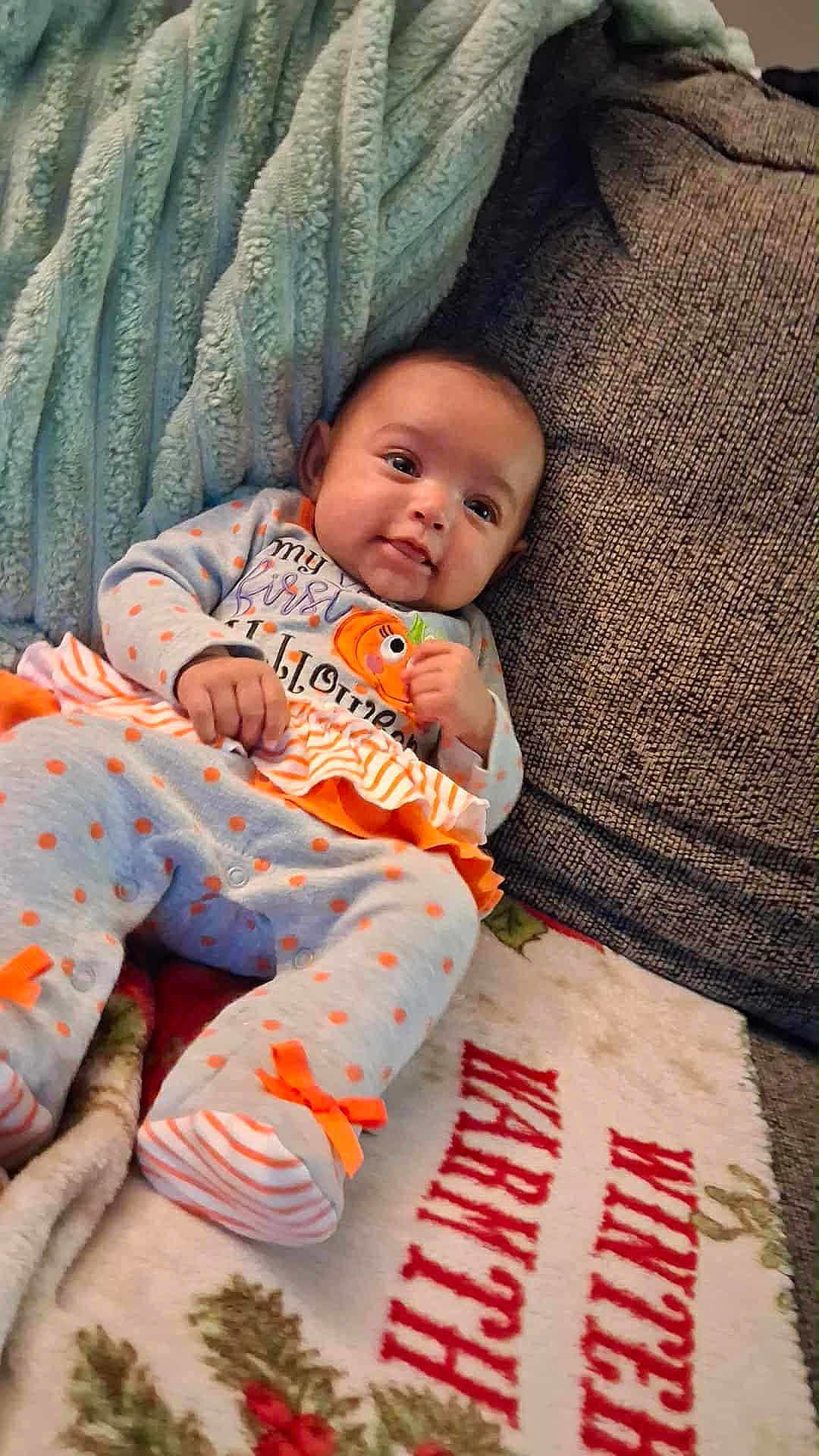 Amariana joined the competition — help win amazing prizes! baby, infant, couch, blanket, clothing, orange, gray, polka_dots, ribbons, face, person, smile, holiday, halloween, decor, home, cozy, soft, toddler, cute