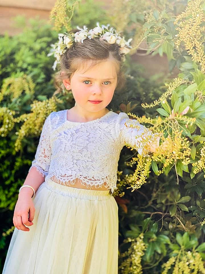 Raegan joined the competition — help win amazing prizes! bridal_clothing, bridal_party_dress, clothing, day_dress, dress, fashion, flower, gown, grass, hair, happy, head, headgear, iris, leaf, person, plant, shoulder, sleeve, textile