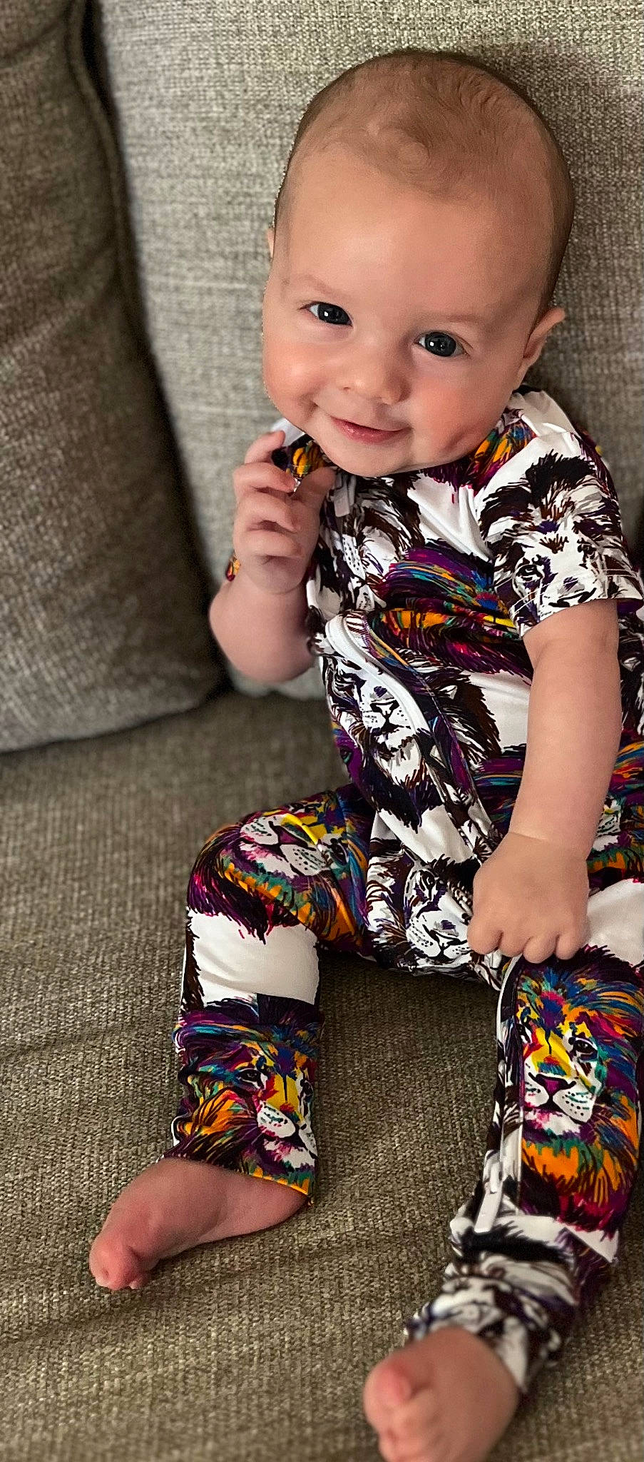 Camden is registered to the contest to win money with this photo: baby, baby_toddler_clothing, child, comfort, flooring, happy, human_leg, lap, linens, pattern, person, play, sitting, skin, sleeve, smile, sock, t_shirt, textile, thigh