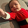 Jules participe au concours pour gagner de l'argent avec cette photo : baby, child, face, red_clothing, couch, indoor, portrait, smiling, toddler, reaching_hand, soft_light, shadow, cute, young_child, comfortable, closeup, person, infant, holiday_outfit, relaxed