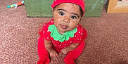 Zavannah joined the competition — help win amazing prizes! baby, child, strawberry_costume, red_clothing, green_collar, hat, carpet, indoor, furniture, wooden_chest, lamp, toy, curious_expression, crawling, cute, person, floor, face, headwear, toddler