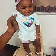 Te'Aari is registered to the contest to win money with this photo: baby, babylaughing, clothing, dimples, face, footwear, happy, head, person, photography, portrait, sandal, sitting, sleeve, smile, standing
