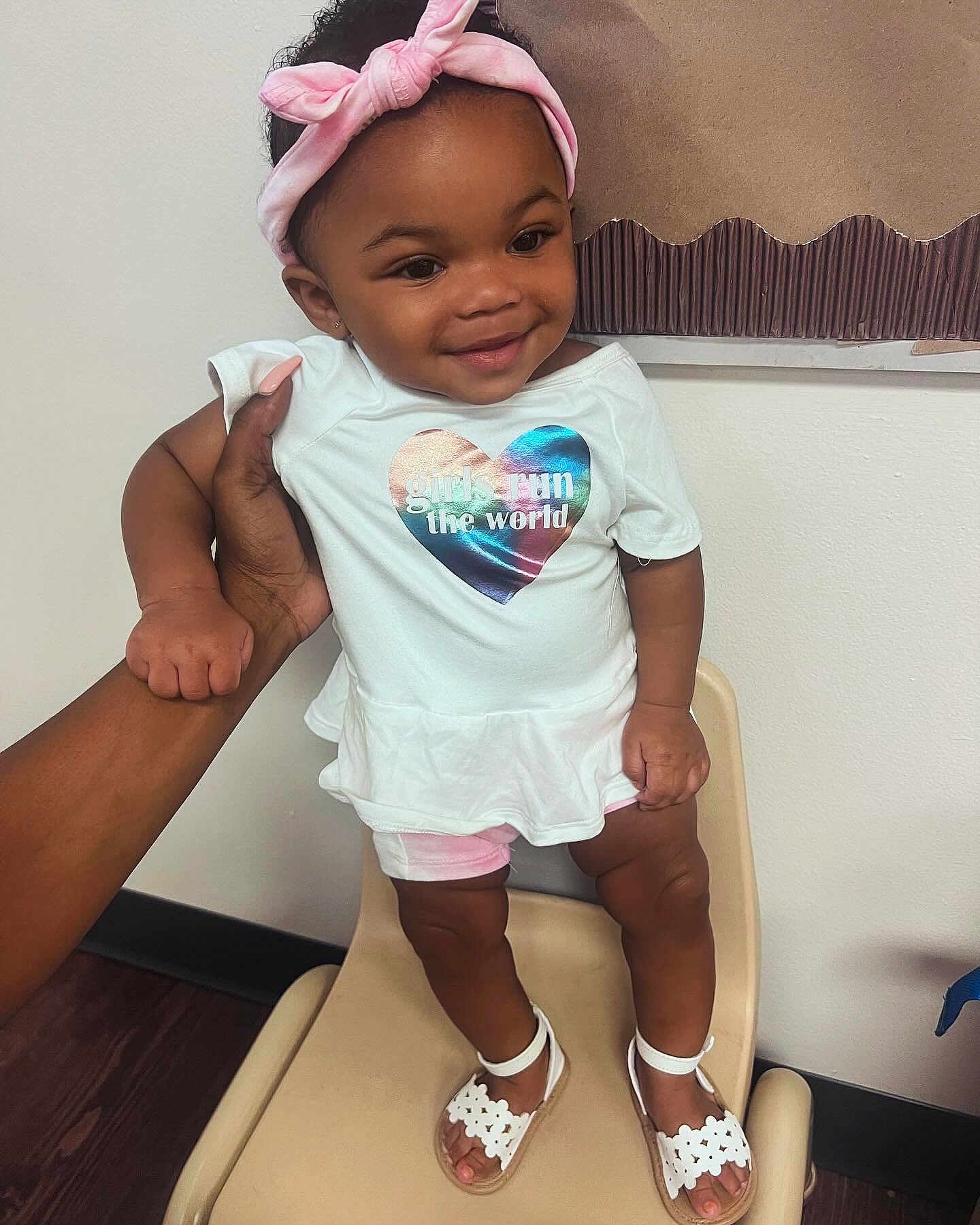 Te'Aari is registered to the contest to win money with this photo: baby, babylaughing, clothing, dimples, face, footwear, happy, head, person, photography, portrait, sandal, sitting, sleeve, smile, standing